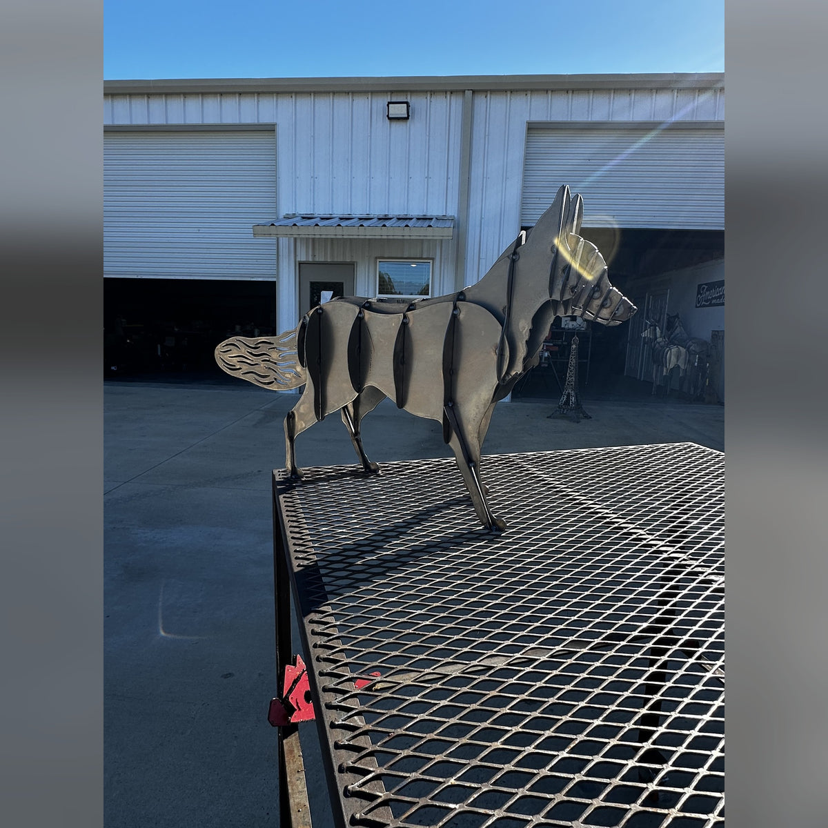 Steel fox sculpture on a steel work table in front of our shop