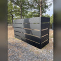 Black steel slat enclosure hiding trash cans and AC unit