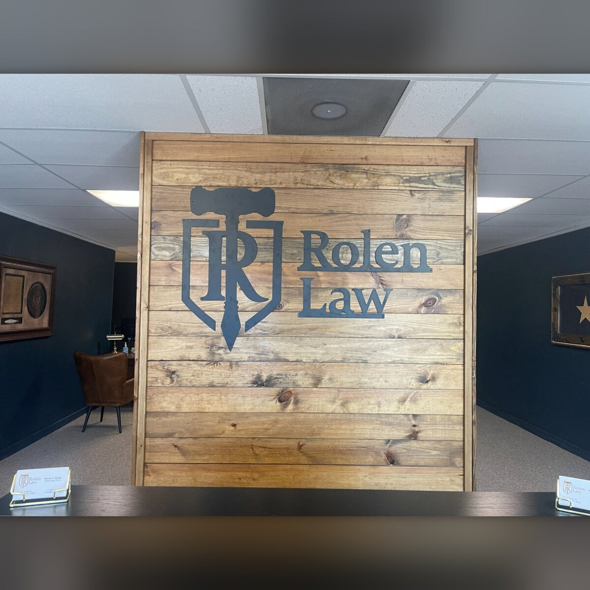 Rolen Law steel logo on wood lobby wall