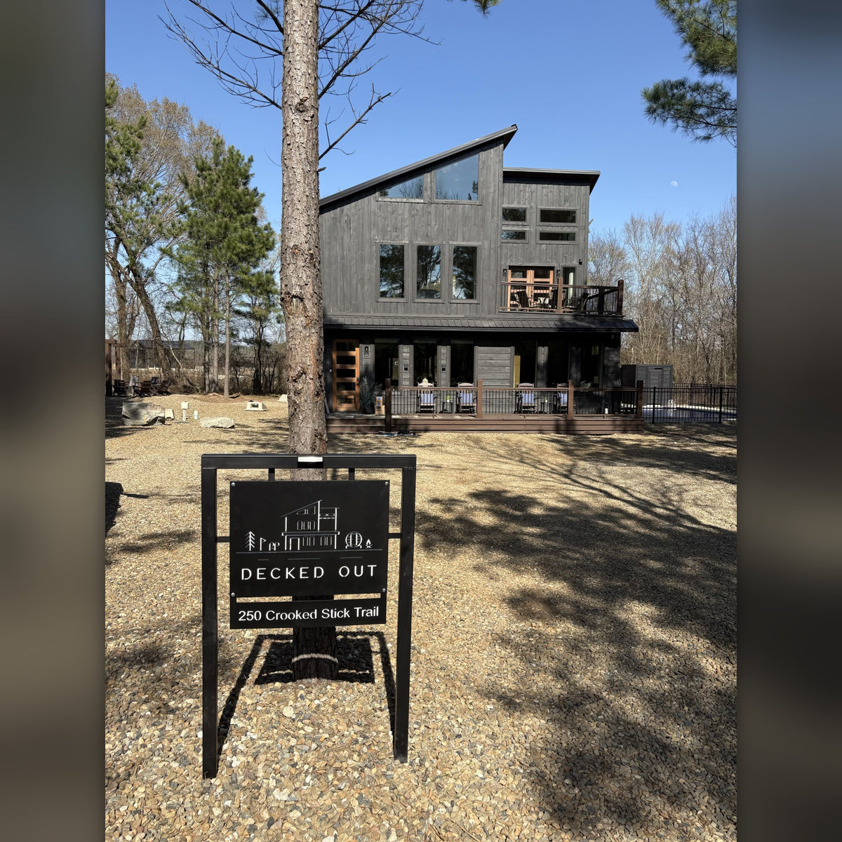 Decked Out 4x3 steel frame cabin road sign in front of a modern black cabin, Broken Bow area